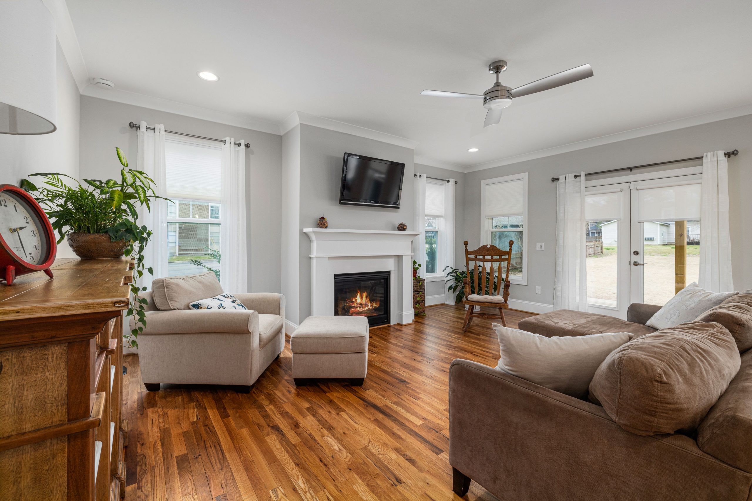Inviting living room featuring a modern fireplace, soft sofas, and elegant wooden flooring.