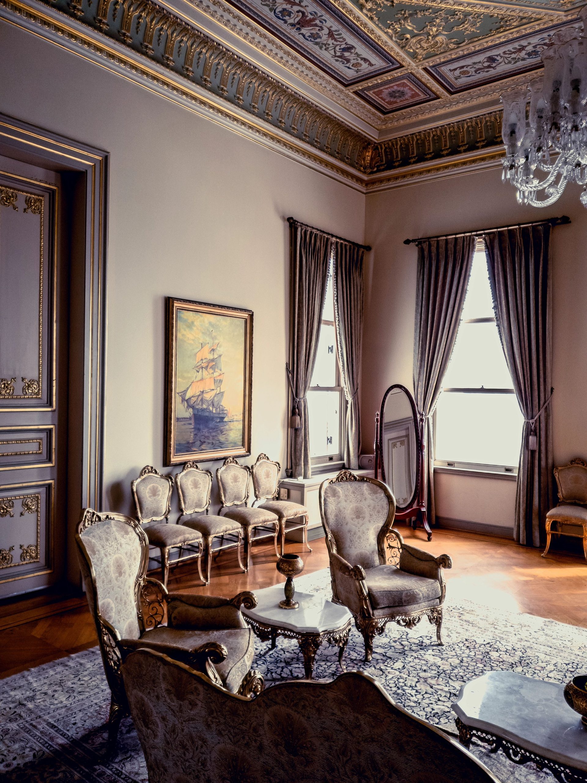 Luxurious antique living room interior featuring elegant furniture and ornate decor in natural light.
