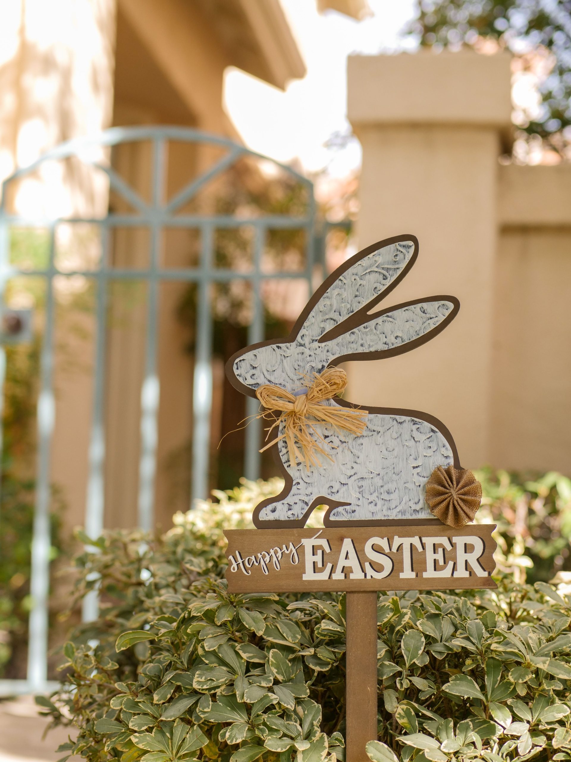 Outdoor Easter bunny sign in a garden, celebrating the spring season.