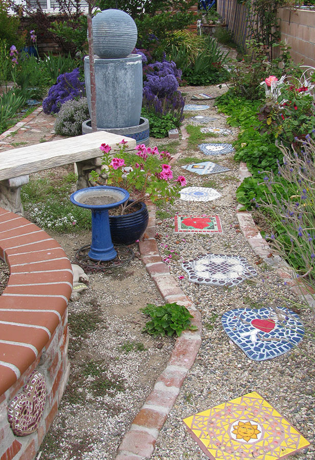 Path of Mosaic Stepping Stones with bench, bird bath, and sculpture. | How To Mosaic Blog