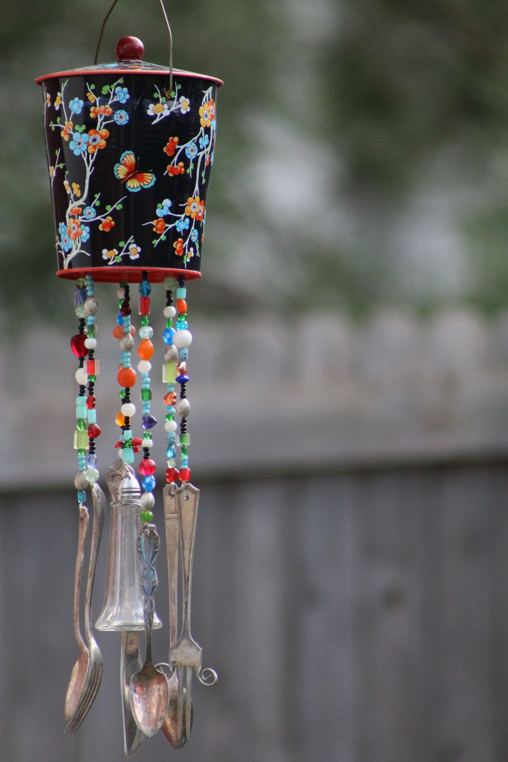 Vibrant handmade wind chime made of beads and cutlery, perfect for outdoor decor.
