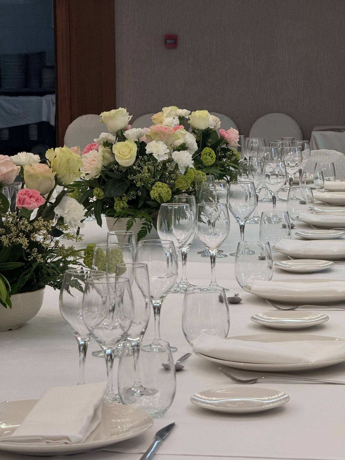 A beautifully arranged dining table with glassware and floral centerpieces in an elegant setting.