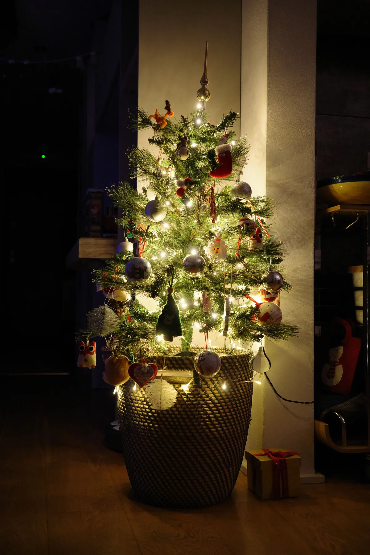 A beautifully decorated Christmas tree glowing warmly indoors during the night.