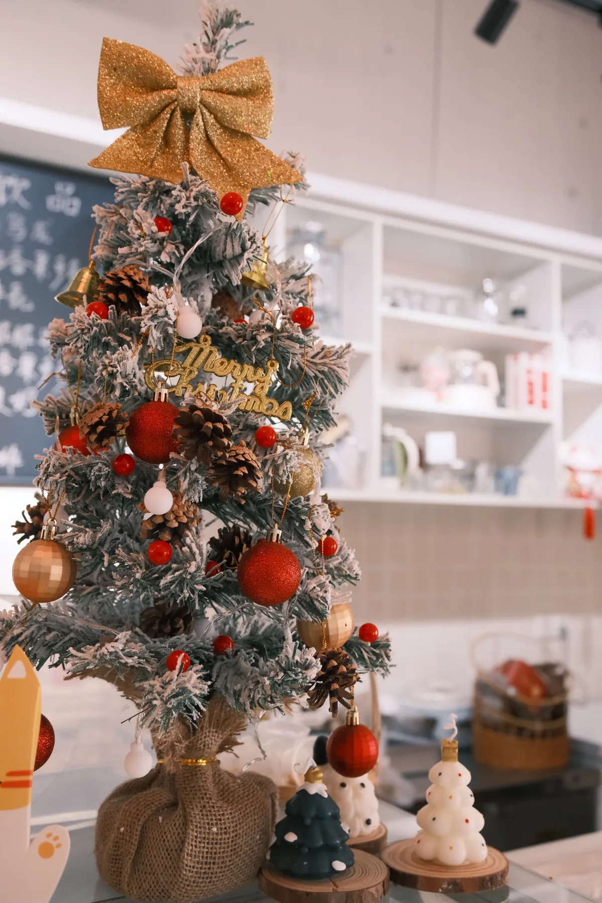 A beautifully decorated Christmas tree with festive ornaments and a golden bow indoors.