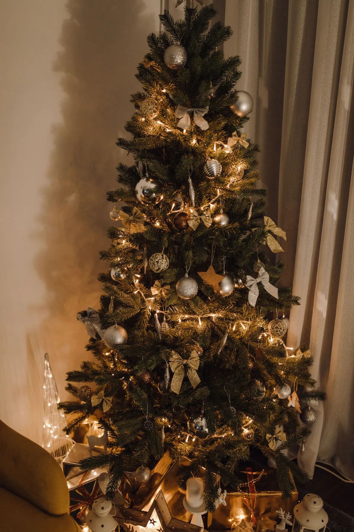 A beautifully decorated Christmas tree with warm lights and ornaments, creating a festive indoor atmosphere.