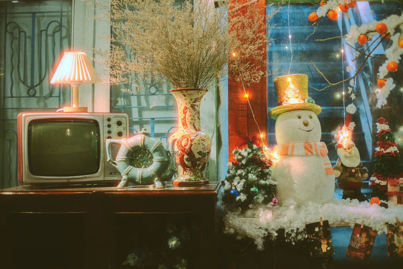 A charming retro Christmas scene featuring a snowman, vintage TV, and festive decorations indoors.