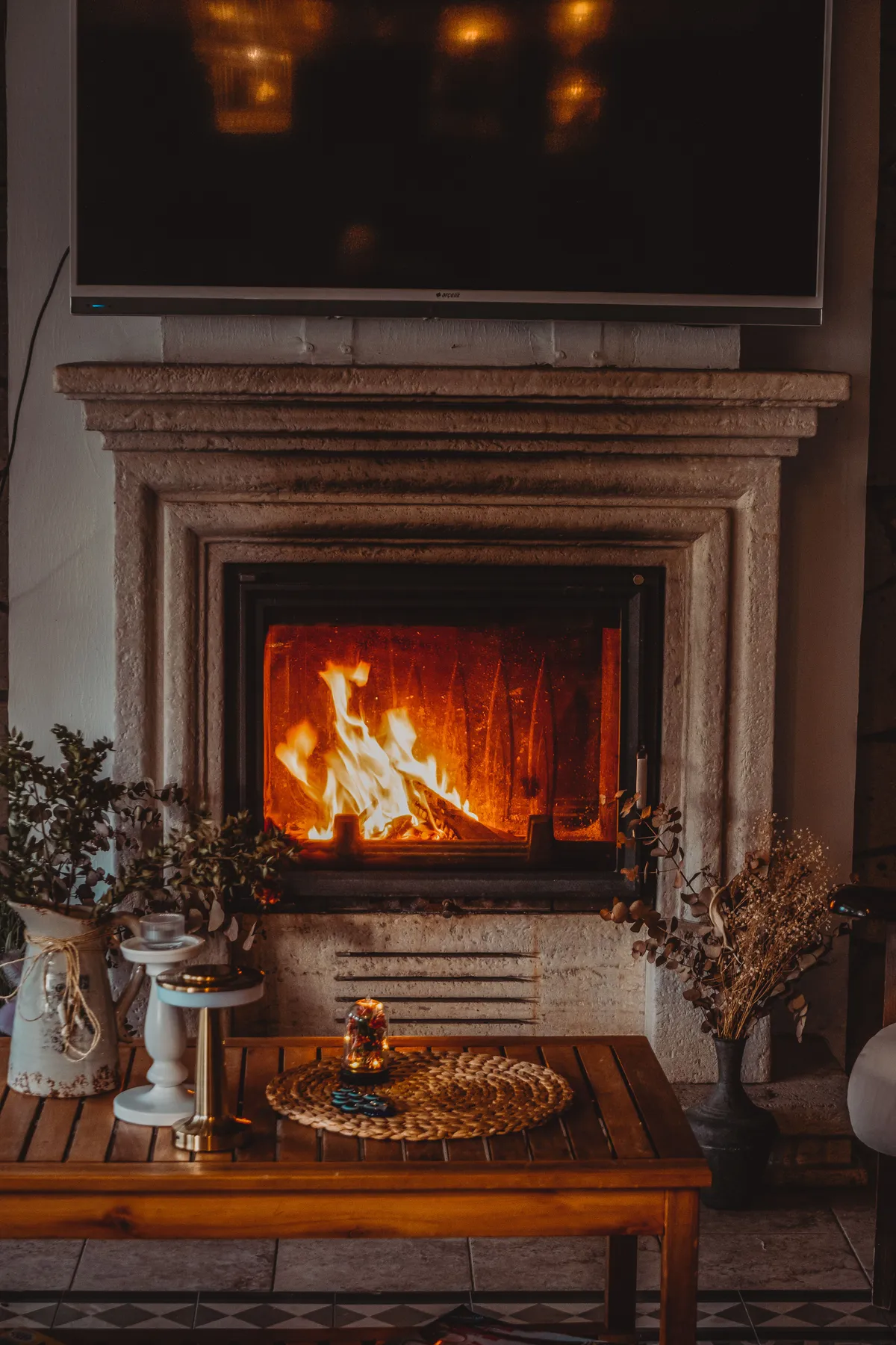 A cozy and elegant interior design featuring a luxurious living room with a lit fireplace.