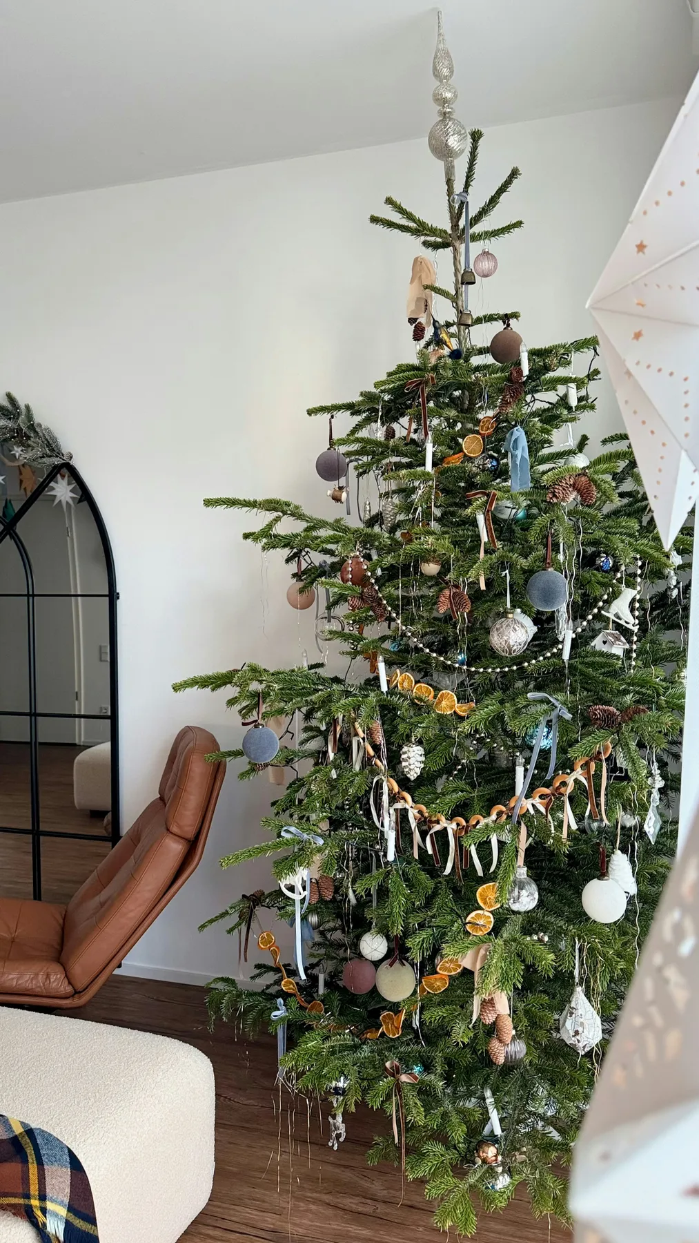 A decorated christmas tree with ornaments and dried oranges