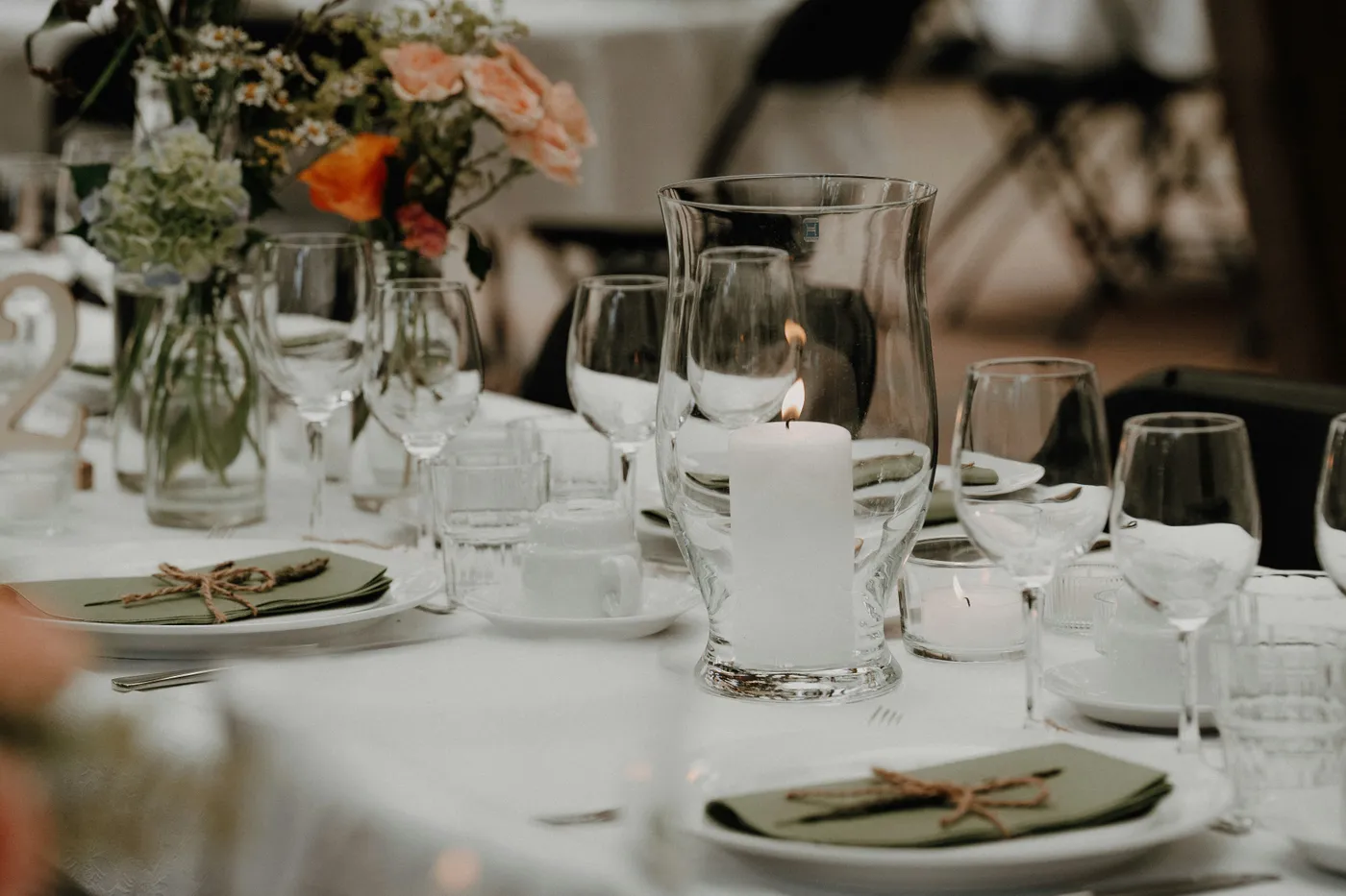 A decorated table setting with a lit candle and flowers