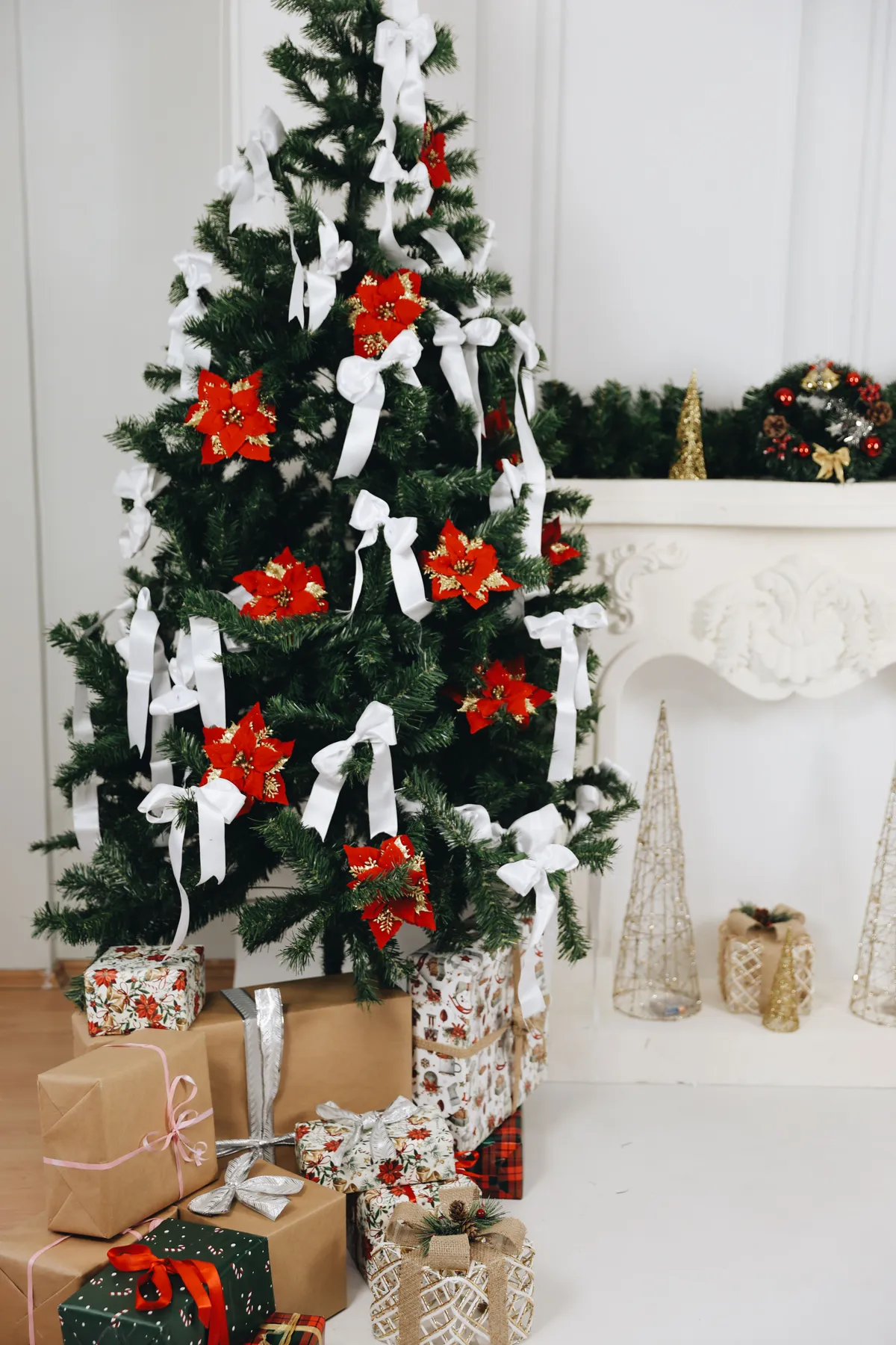 A festive Christmas tree with presents underneath, adorned with red and white decorations.