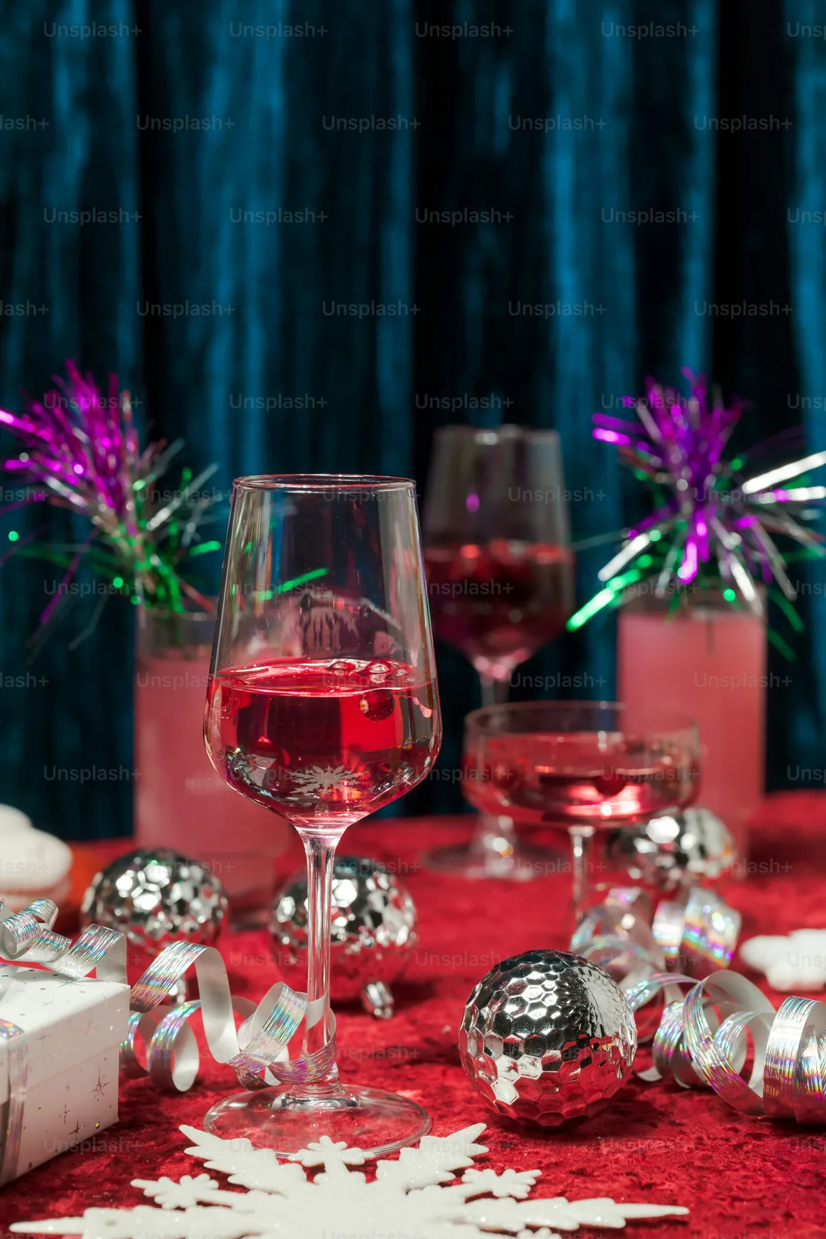 A table topped with wine glasses filled with red wine - Photo on Unsplash+