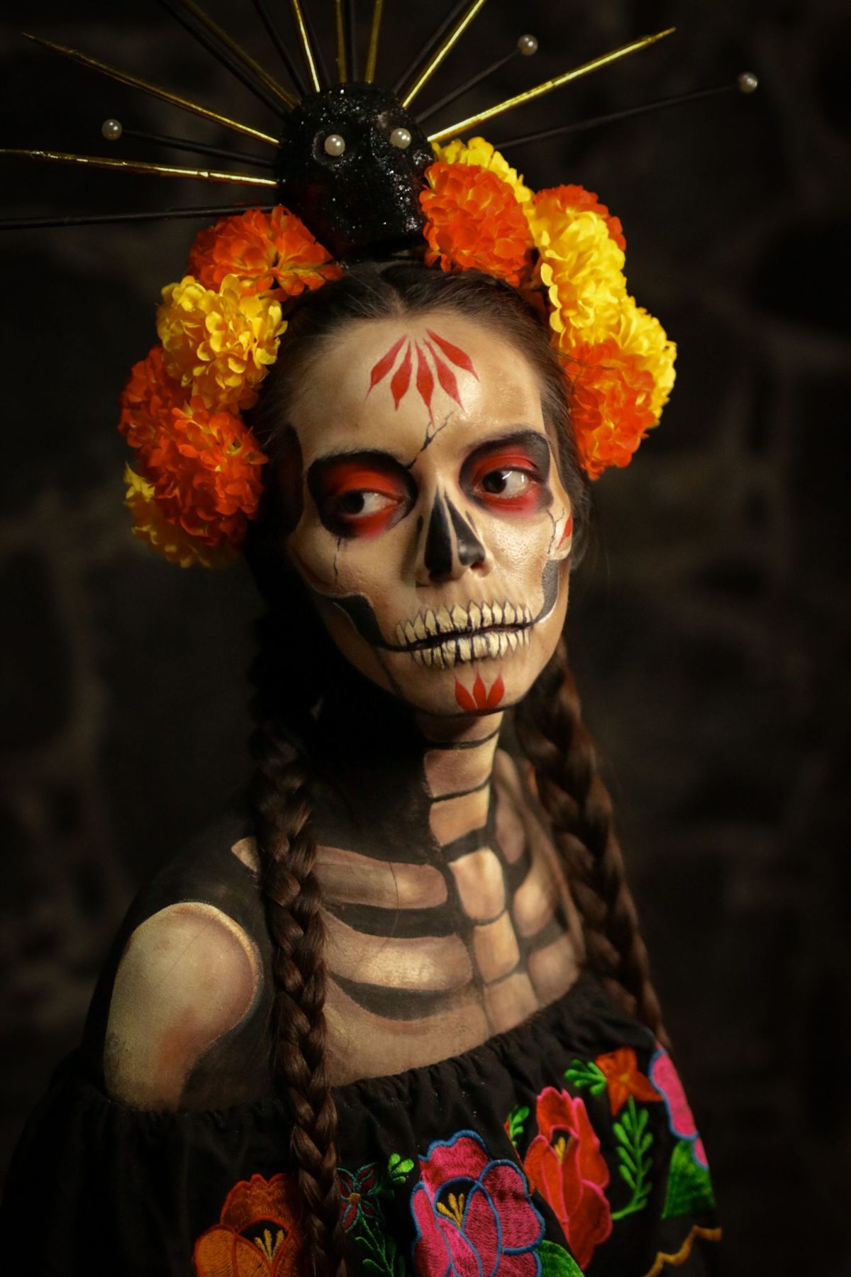Artistic Día de los Muertos portrait with vibrant floral crown and skeletal makeup. Ideal for holiday and cultural themes.