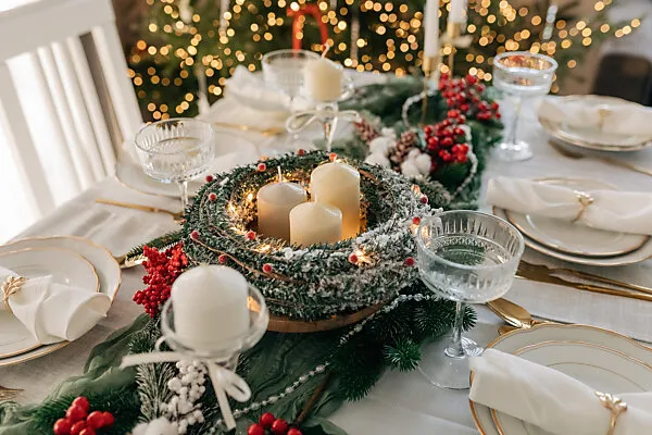 Bildagentur | mauritius images | From above christmas table settings with a wreath decoration with white and golden dinnerware on fluffy placemat on pink tablecloth