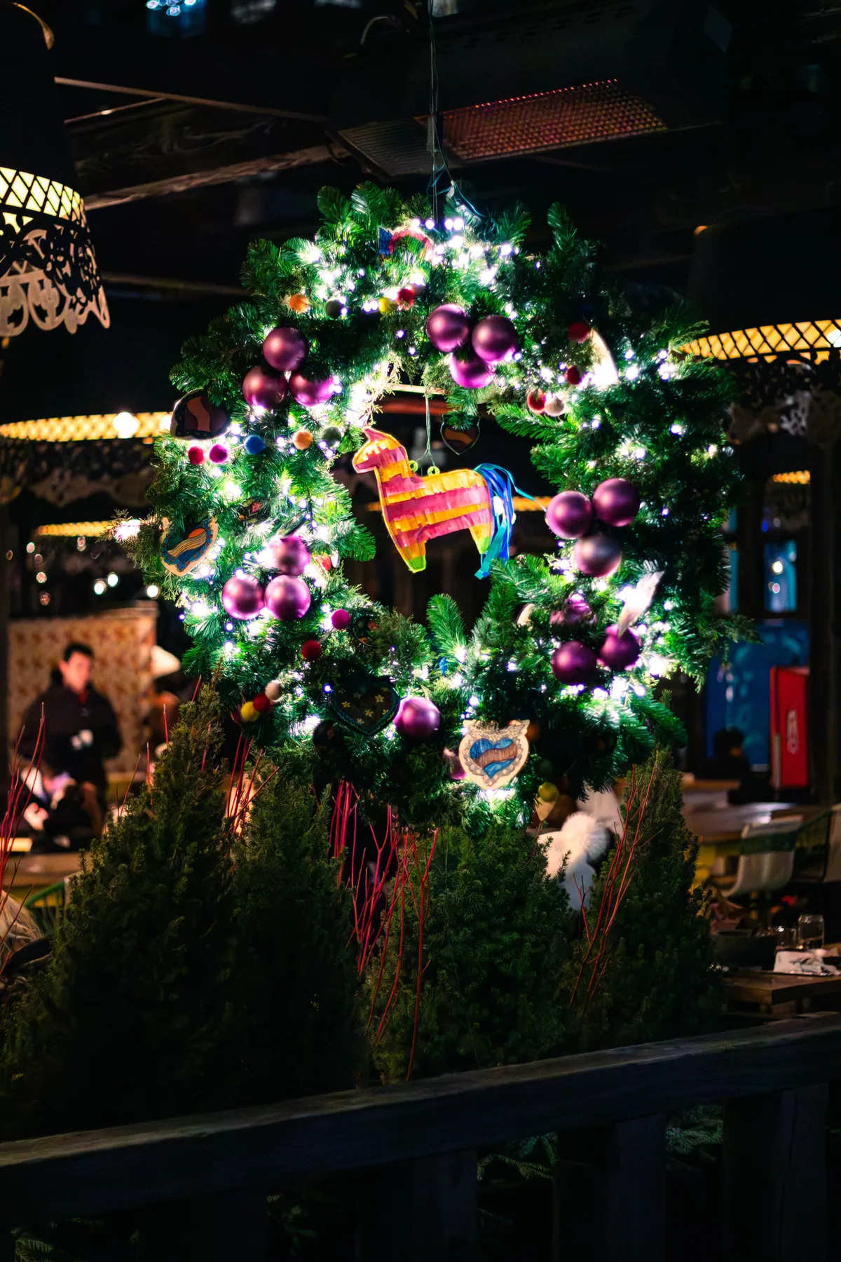 Brightly lit Christmas wreath adorned with a colorful pinata and festive decorations.