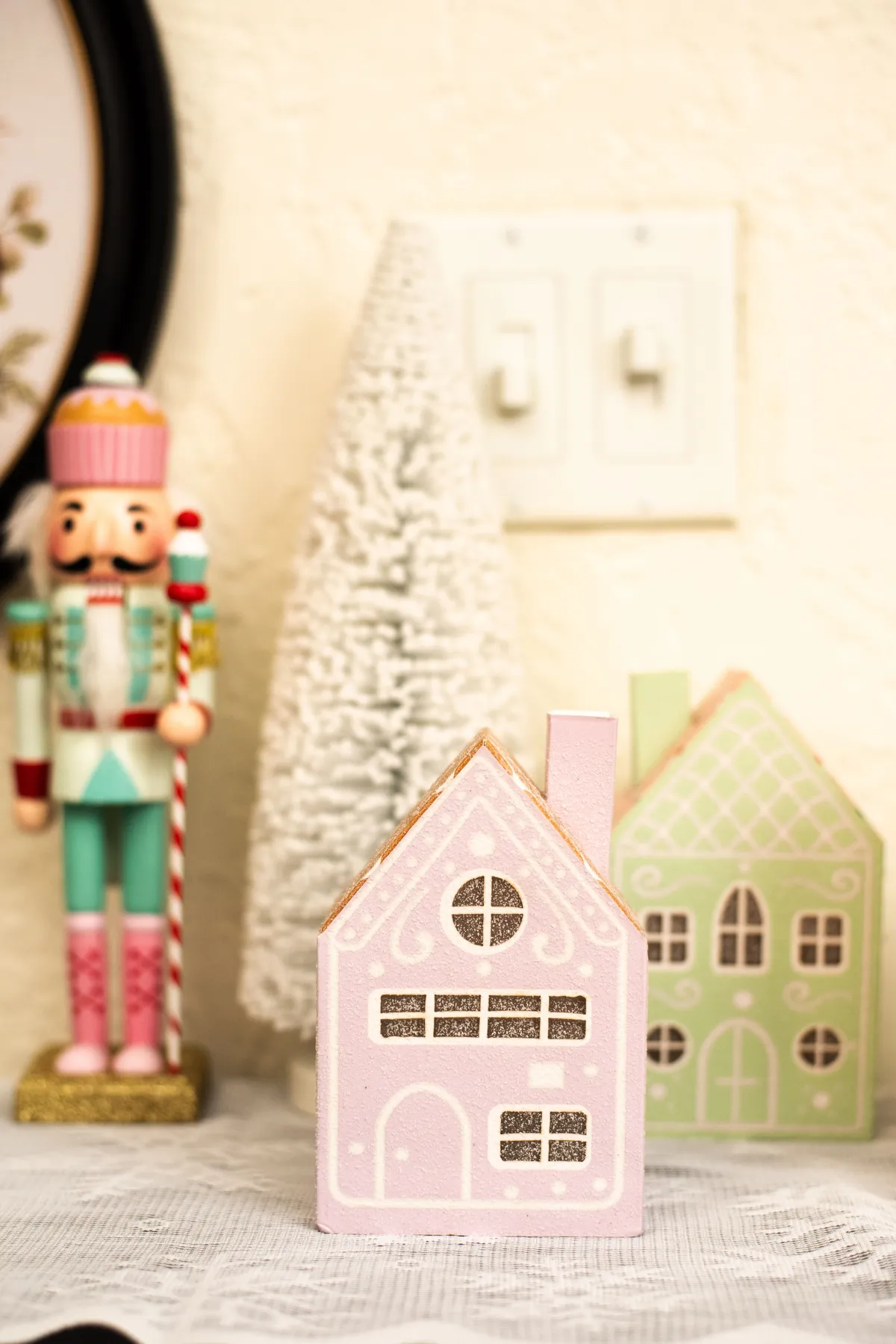 Charming Christmas decor featuring a nutcracker and pastel gingerbread houses.