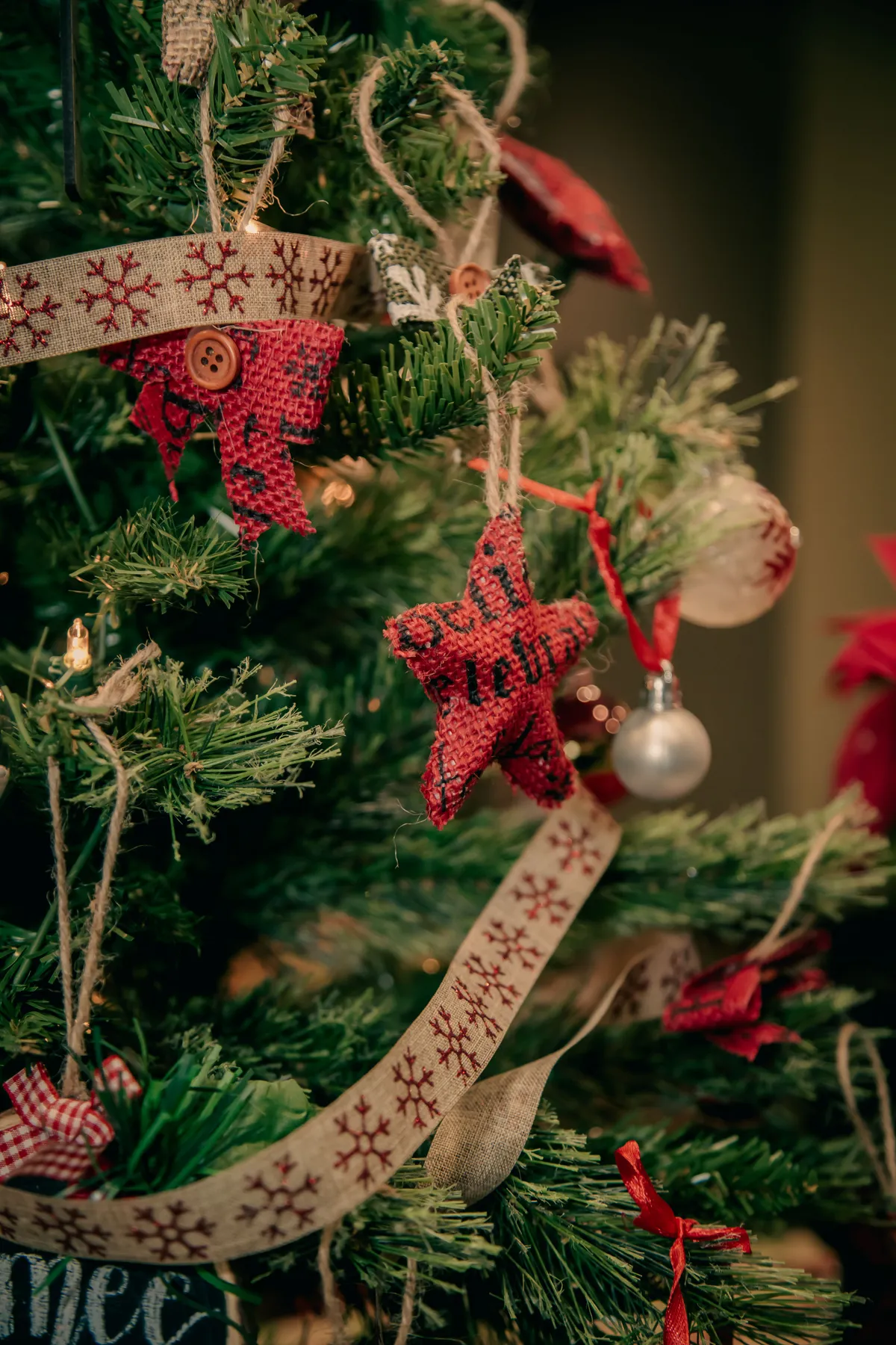 Close-up of a Christmas tree adorned with star-shaped ornaments and festive ribbons.