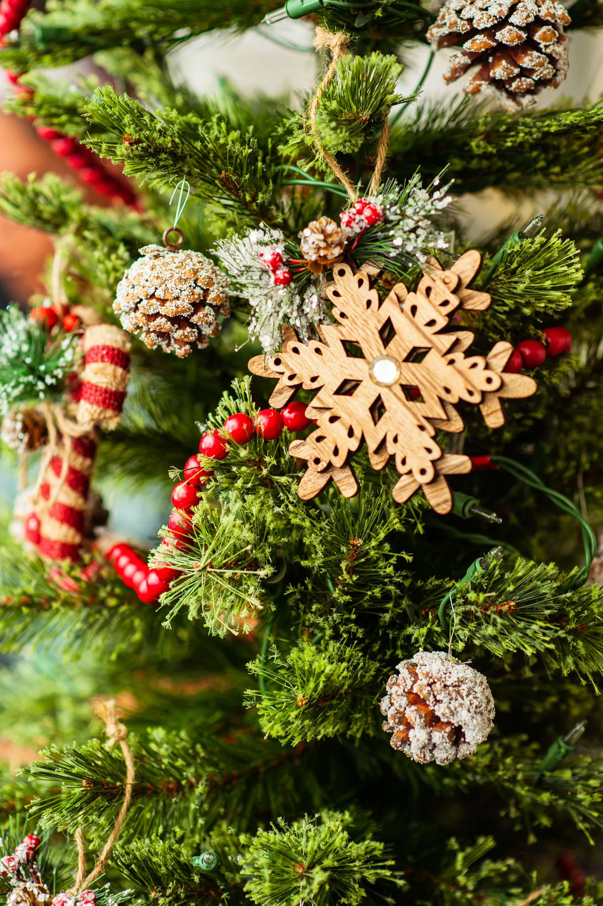 Close-up of a decorated Christmas tree with snowflake and pinecone ornaments, capturing the festive spirit.