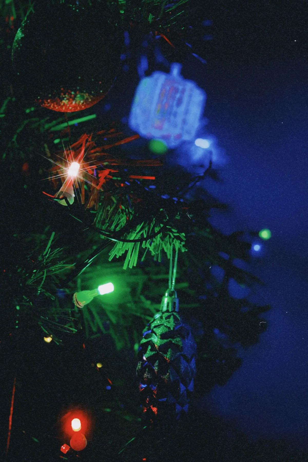 Close-up of Christmas tree with glowing lights and ornaments, creating a festive atmosphere.