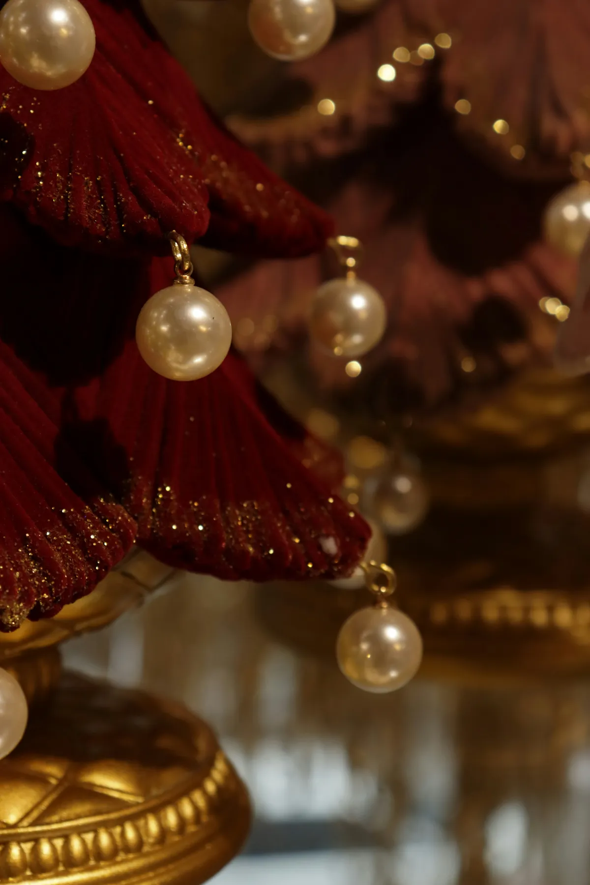Close-up of decorative red and gold ornaments with pearl accents