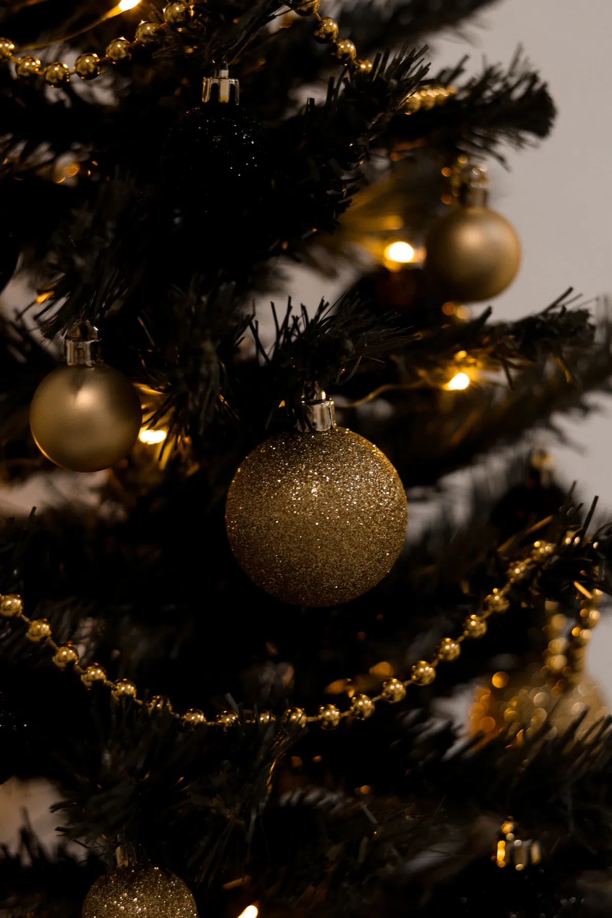 Close-up of golden baubles and lights on a decorated Christmas tree, capturing the festive spirit.