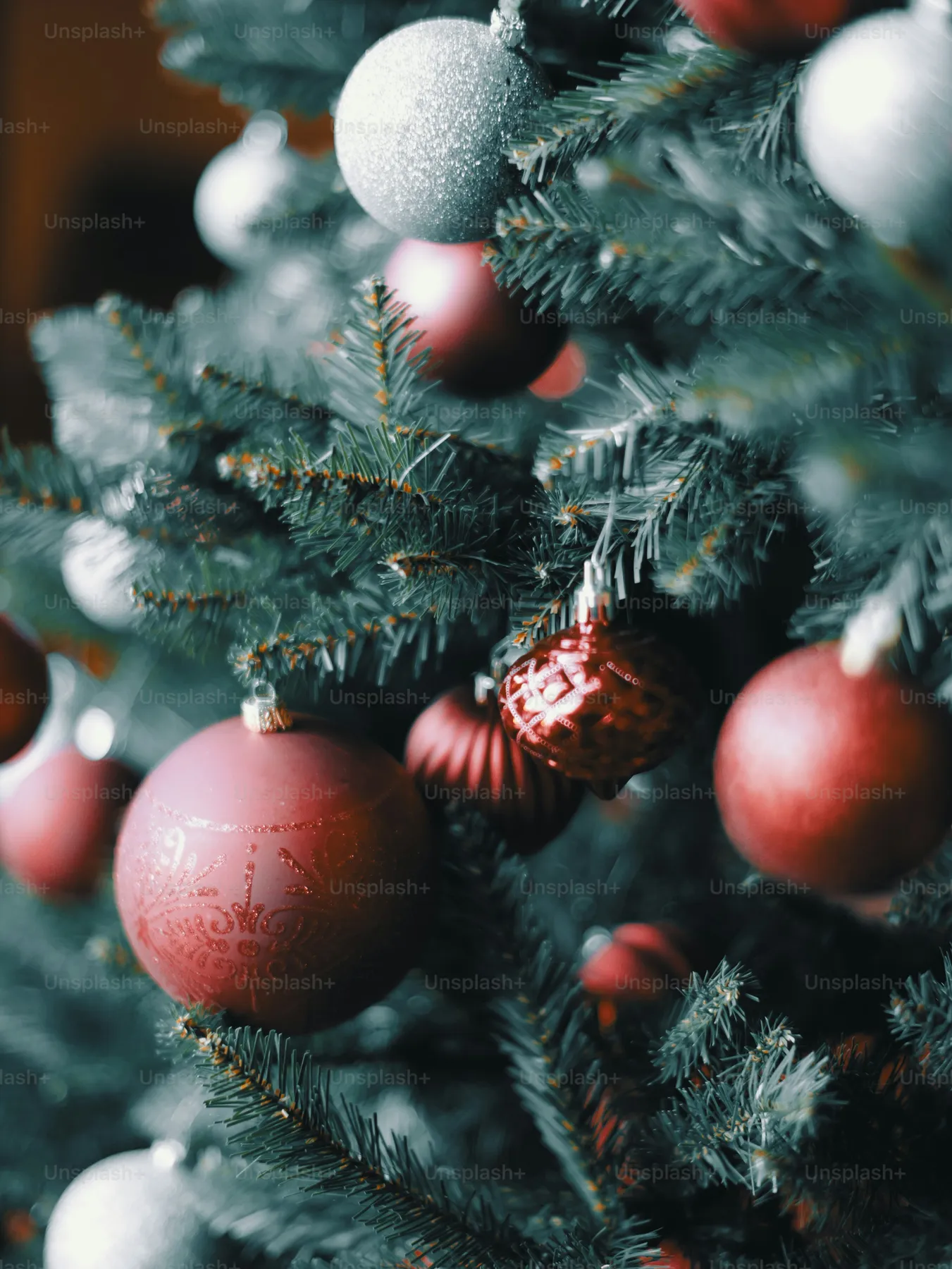 Close-up of red and silver ornaments on a christmas tree - Photo on Unsplash+