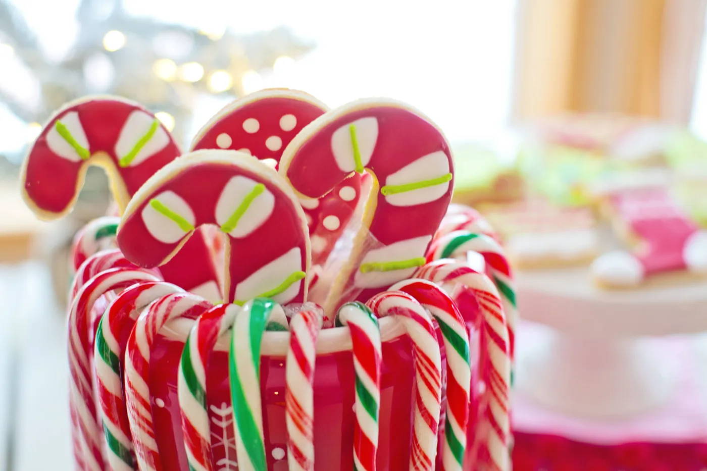 Colorful candy canes and cookies in a holiday-themed setup, perfect for Christmas.