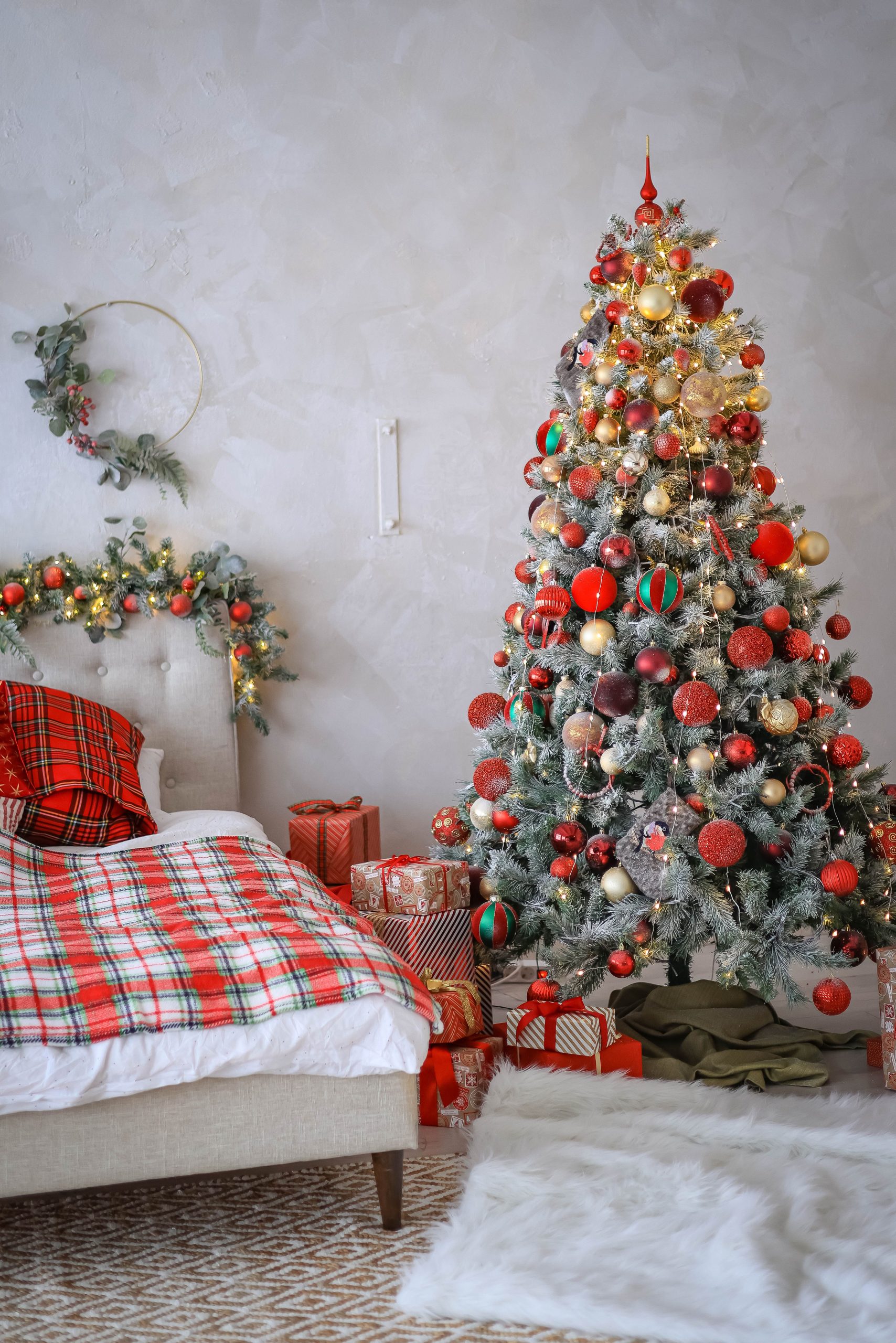 Cozy Christmas-themed bedroom with a decorated tree and gifts in a warm setting.