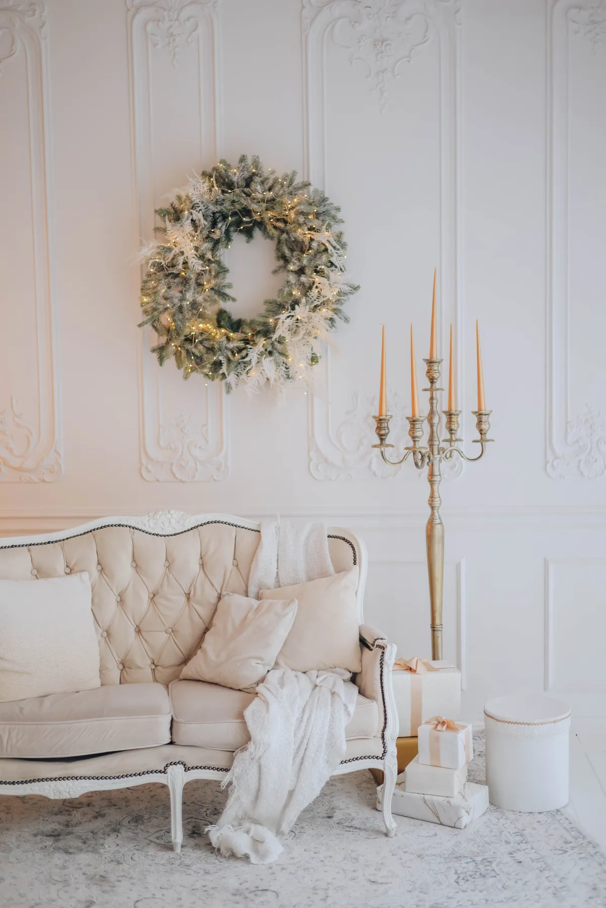 Cozy living room with a classic sofa, candelabra, and festive wreath.
