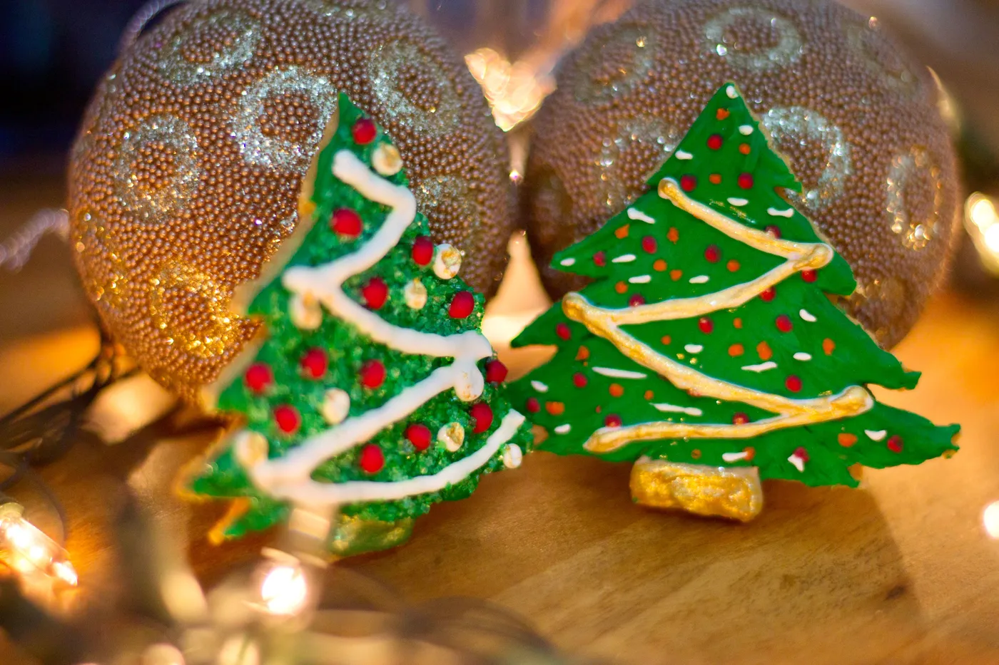 Decorated Christmas tree cookies with ornaments and lights create a festive holiday feel.