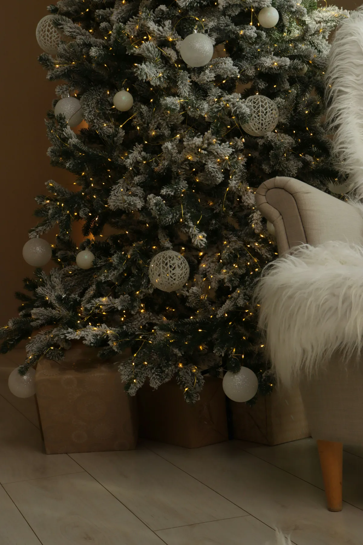 Decorated christmas tree with presents and armchair