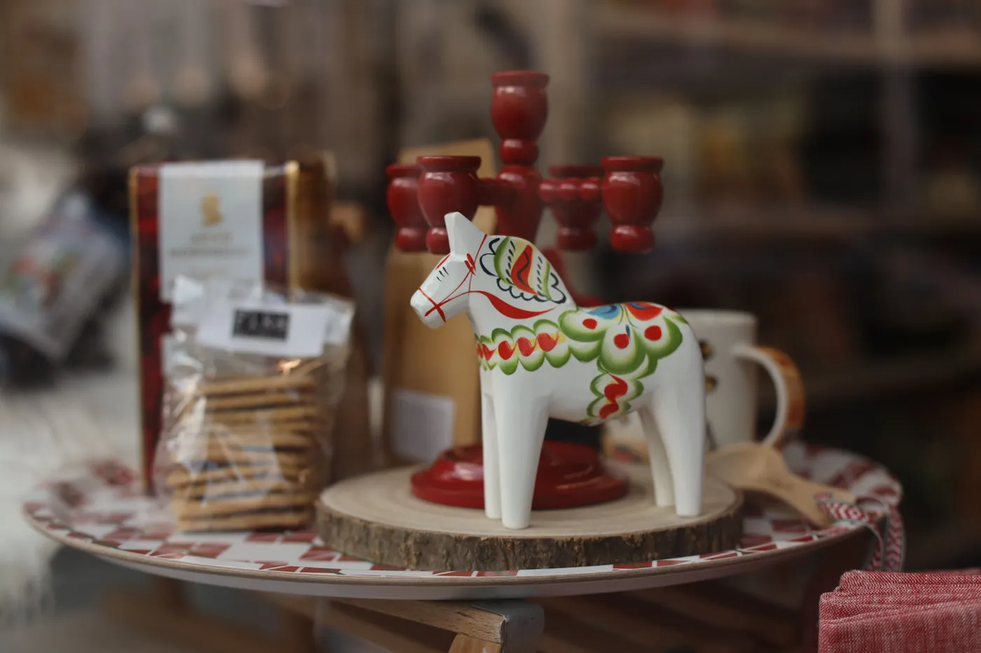 Decorative wooden ornament horse paired with red candlesticks in a cozy setting.