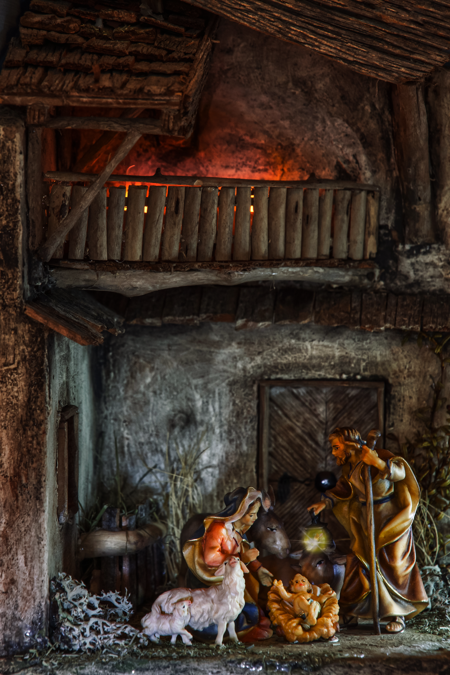 Detailed nativity scene with figurines depicting birth of Jesus in a rustic stable setting.