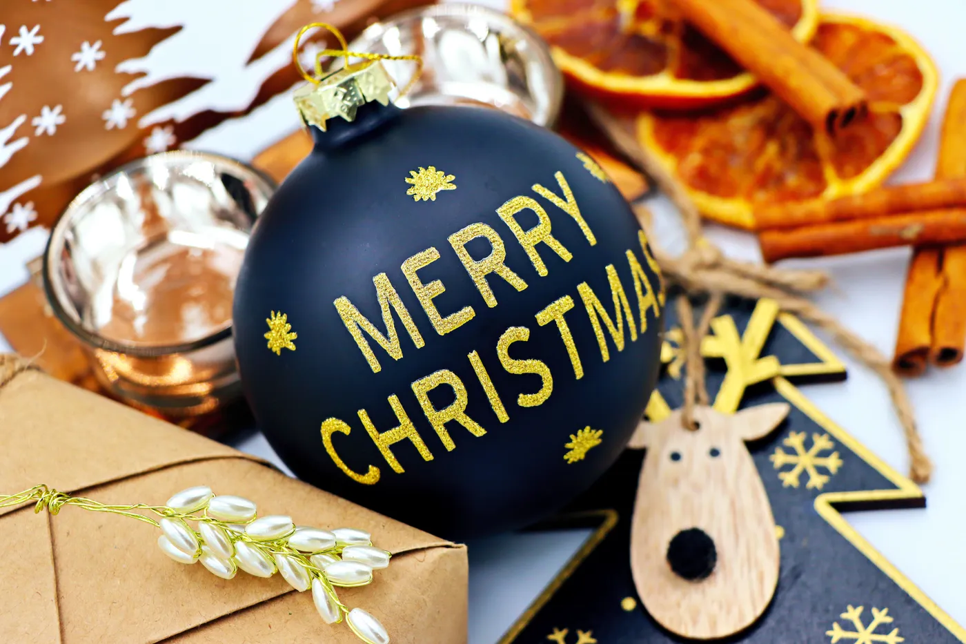 Elegant Christmas scene with black ornament, cinnamon, dried oranges, and festive decorations.