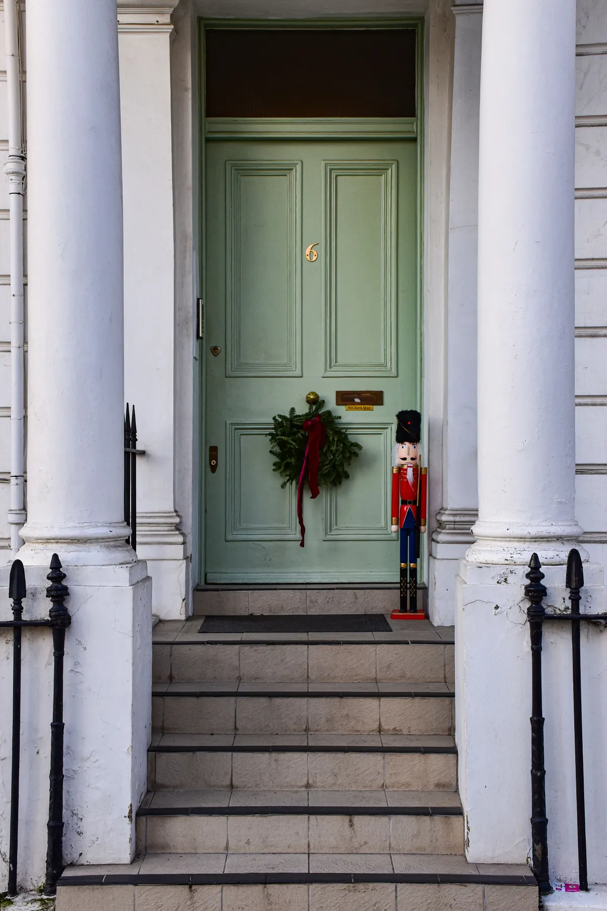 Elegant doorway in London with holiday wreath and toy soldier decor, perfect for festive themes.