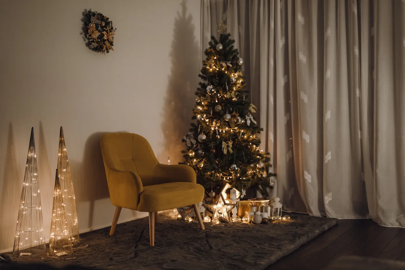 Elegant indoor Christmas scene with tree, lights, and cozy armchair.