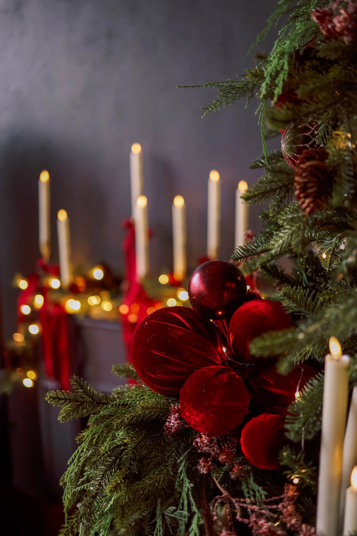 Festive Christmas decor with red ornaments and glowing candles.