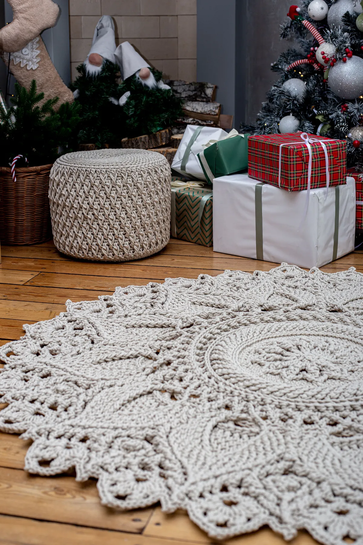 Festive living room with Christmas tree, presents, and a crochet rug.