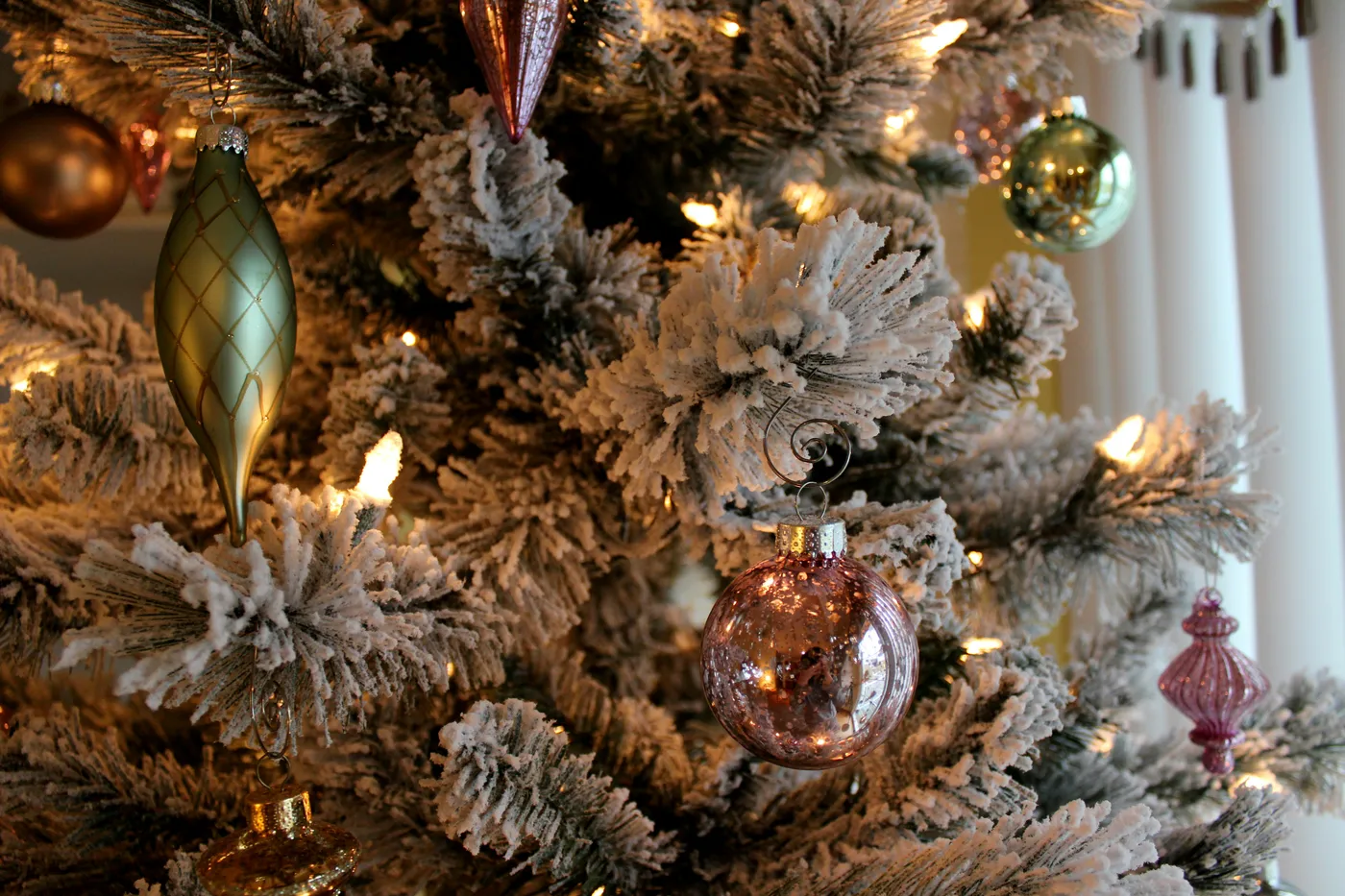 Flocked Christmas tree with ornaments.