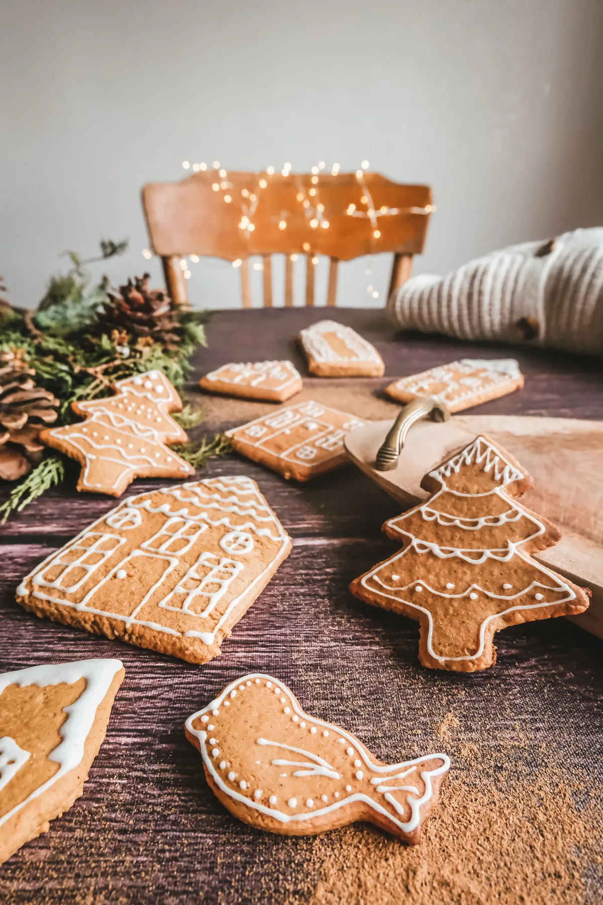 Homemade gingerbread cookies on a wooden table evoke a cozy Christmas charm with warm, festive decor.