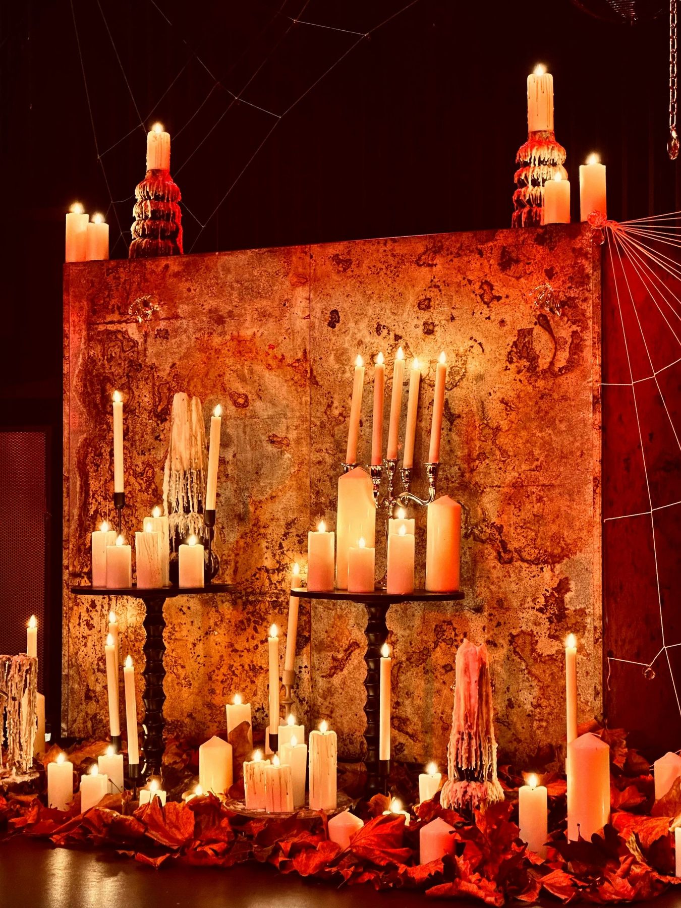 Many lit candles on a rustic display