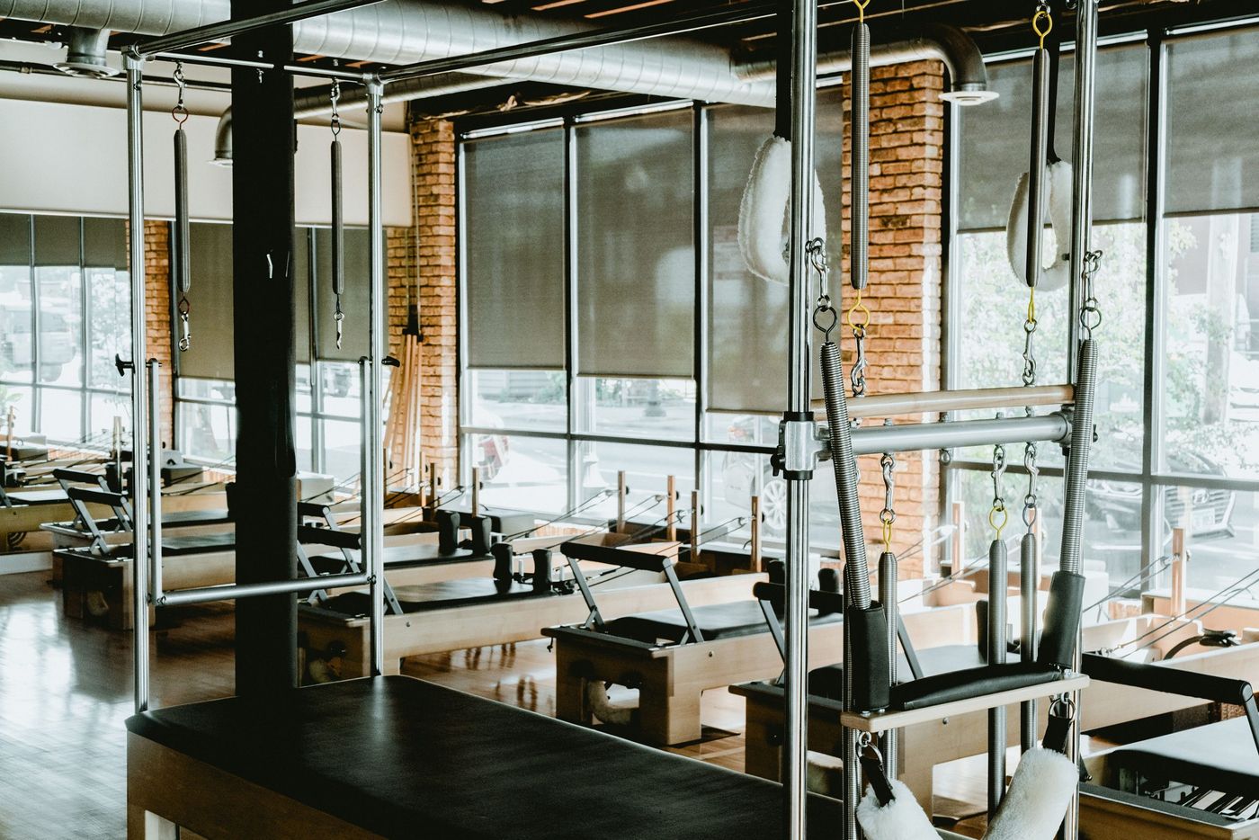 Spacious and well-equipped Pilates studio featuring reformers and other fitness equipment.