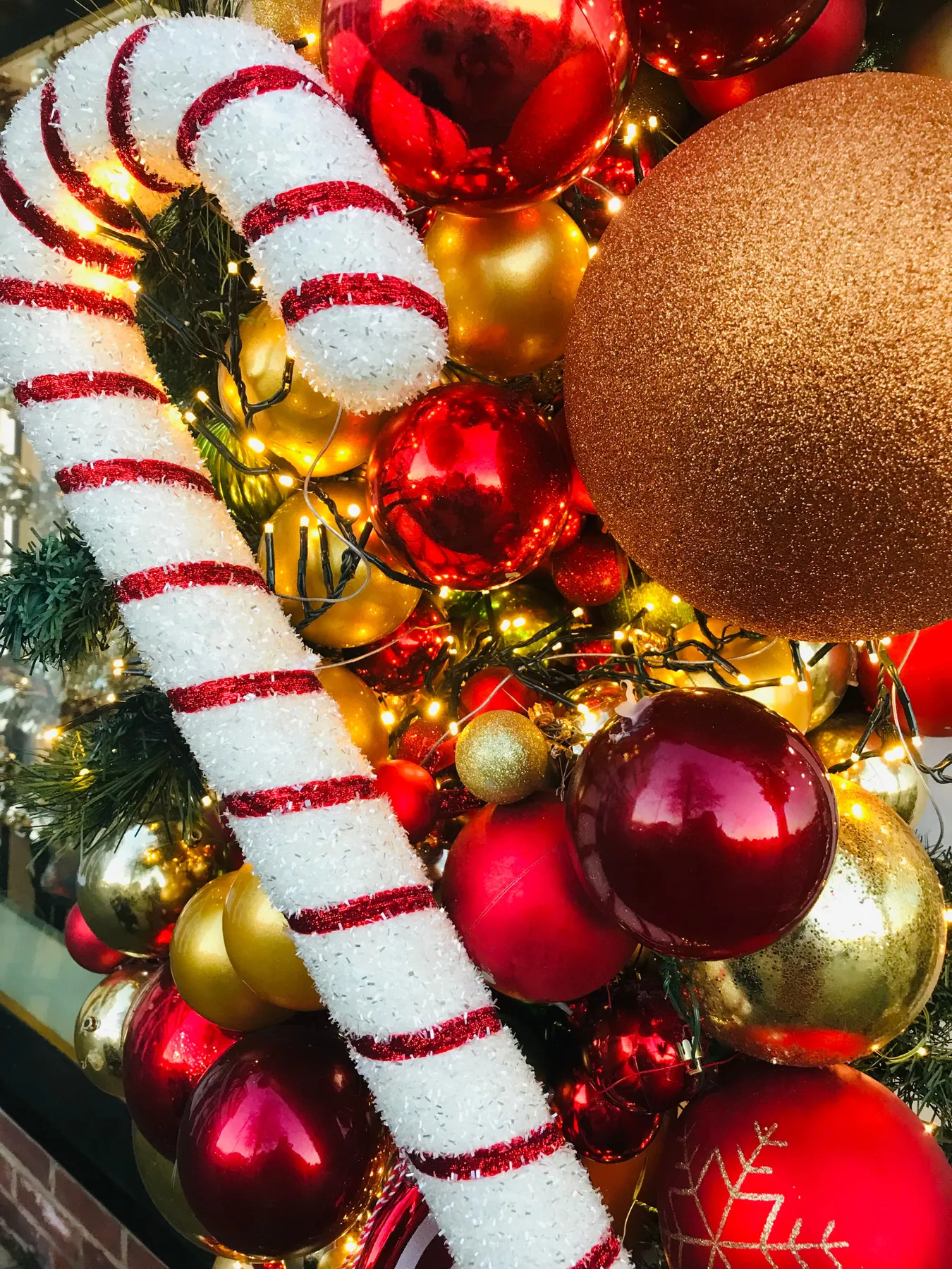 Vibrant Christmas decoration with candy cane and colorful ornaments, perfect for holiday themes.