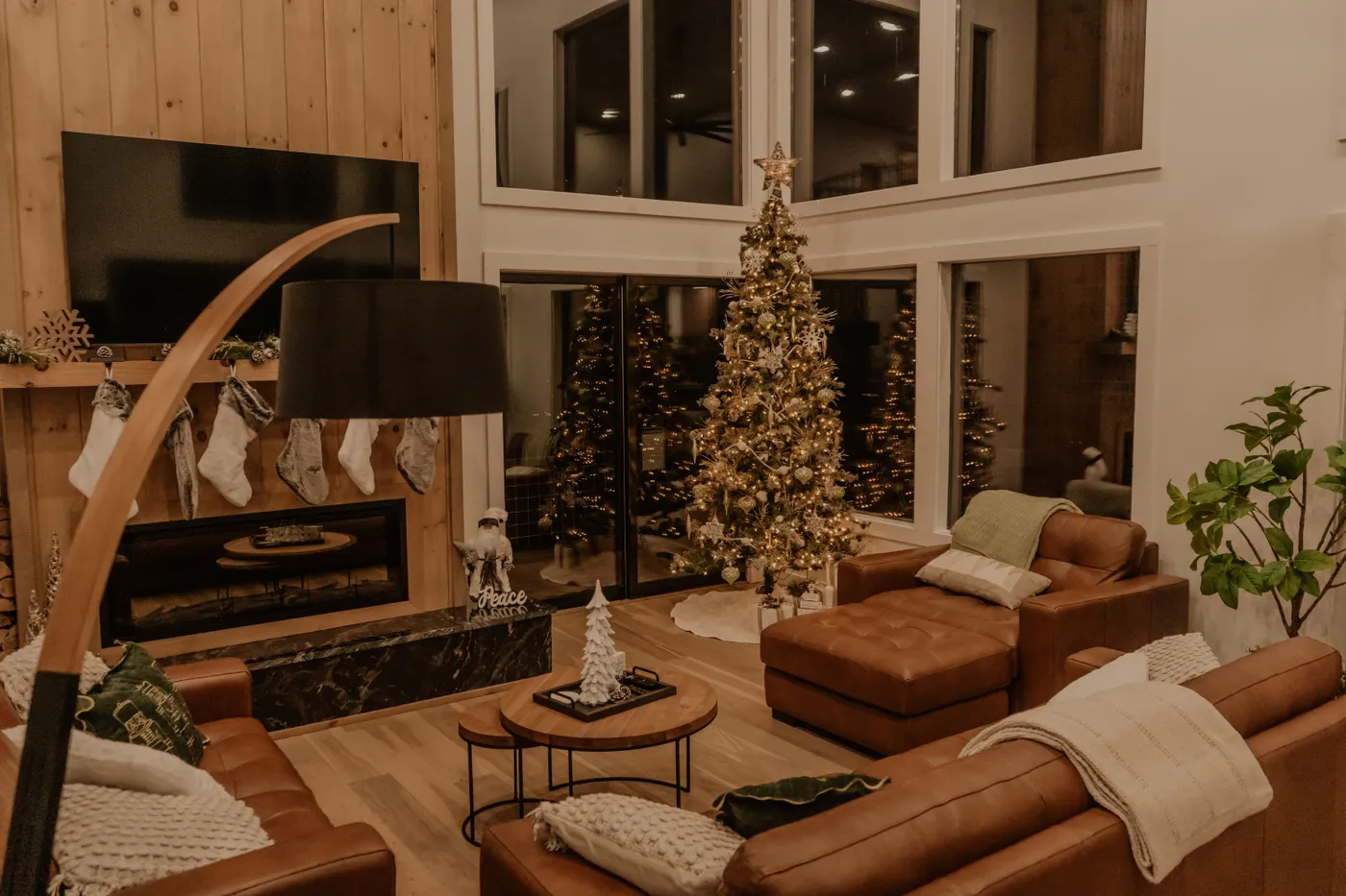 Warm living room with Christmas tree and fireplace, perfect for holiday ambiance.